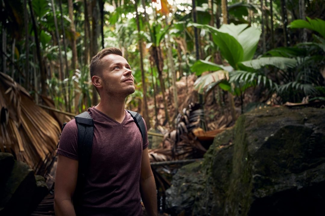 young-man-with-backpack-discovering-jungle-traveler-in-tropical-rainforest-in-seychelles- Home